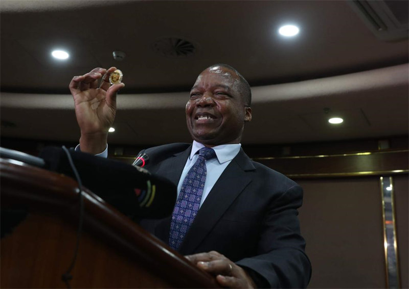 Gavana wa Benki Kuu ya Zimbabwe John Mangudya akionyesha sarafu mpya ya dhahabu kwenye mkutano na waandishi wa habari mjini Harare, Zimbabwe, Julai 25, 2022. (Picha na Shaun Jusa/Xinhua)