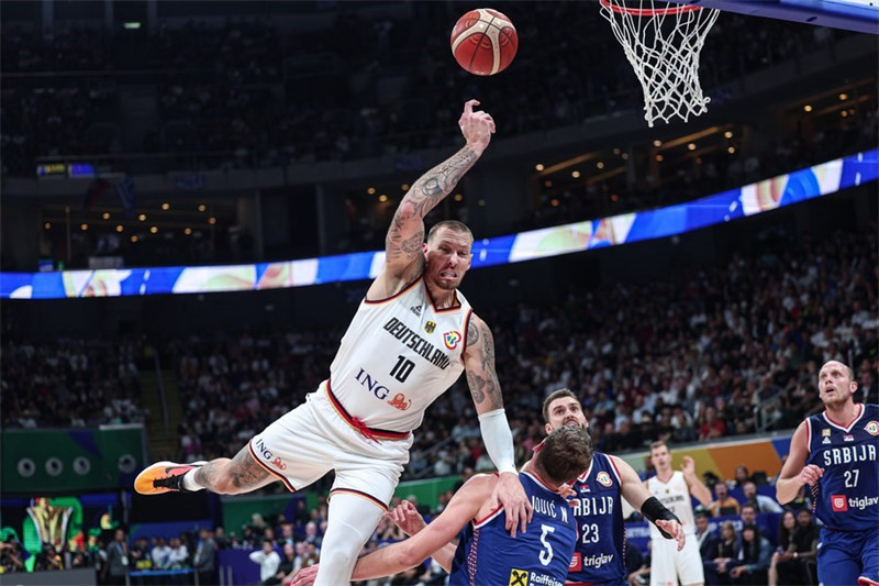 Daniel Theis (Kushoto) wa Ujerumani akipoteza uwiano wa mwili katika mchezo wa fainali dhidi ya Serbia kwenye Kombe la Dunia la Mpira wa Kikapu la FIBA 2023 huko Manila, Ufilipino, Septemba 10, 2023. (Xinhua/Wu Zhuang)