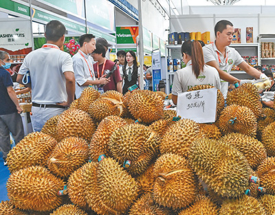 Wafanyabiashara wa Vietnam wakiuza matunda ya madoriani katika Eneo la Maonyesho ya Bidhaa za ASEAN la Maonesho ya 20 ya China-ASEAN. (Picha na Zhang Ailin/Xinhua)