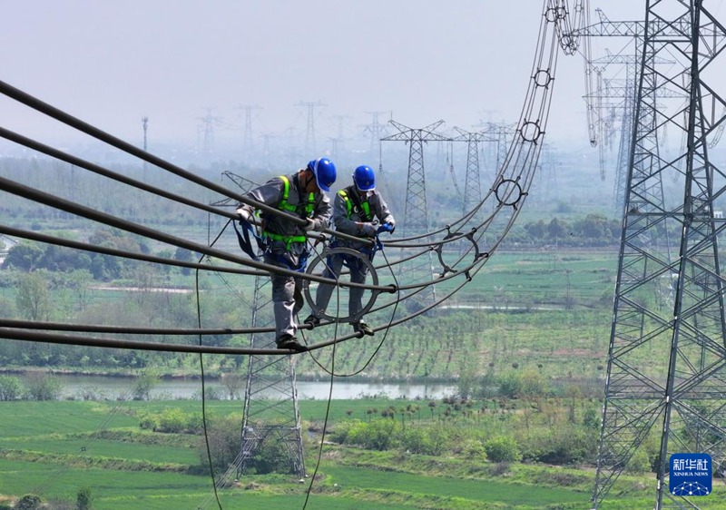 Wafanyakazi wa Kampuni ya Gridi ya Taifa ya China tawi la Hefei wakifanya ukaguzi na ukarabati wa juu kwenye mnara ya namba 3418 ya laini ya umeme ya Jiansu katika Wilaya ya Lujiang, Mji wa Hefei, Mkoa wa Anhui, China, Aprili 9.