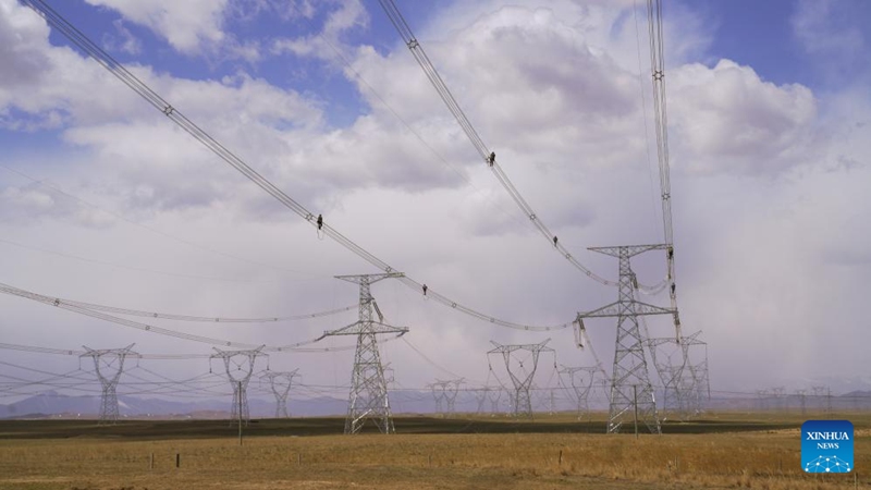 Wafanyakazi wa kampuni ya Gridi ya Taifa ya China tawi la Qinghai wakifanya kazi kwenye mradi wa umeme wa 750-kV katika Wilaya ya Gonghe, Tarafa inayojiendesha ya Kabila la Watibet ya Hainan, Mkoa wa Qinghai, Kaskazini Magharibi mwa China, Aprili 23, 2024. (Picha na Wang Xiaogang/Xinhua)