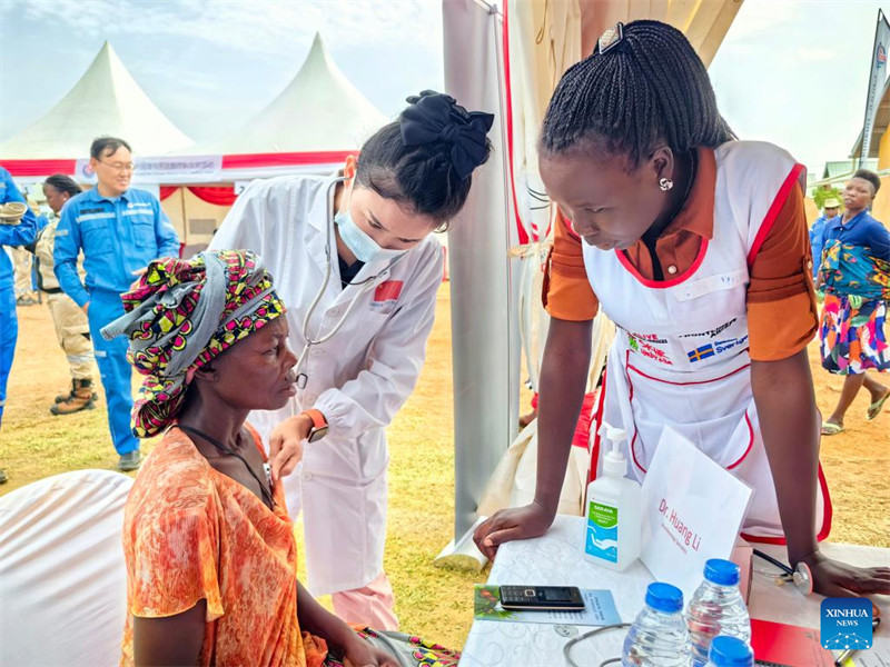 Daktari kutoka timu ya madaktari wa China nchini Uganda akimpima mkaazi kwenye kambi ya matibabu iliyoandaliwa katika Wilaya ya Kikuube, Magharibi mwa Uganda, Juni 19, 2024. (Picha na Tian Yu/Xinhua)