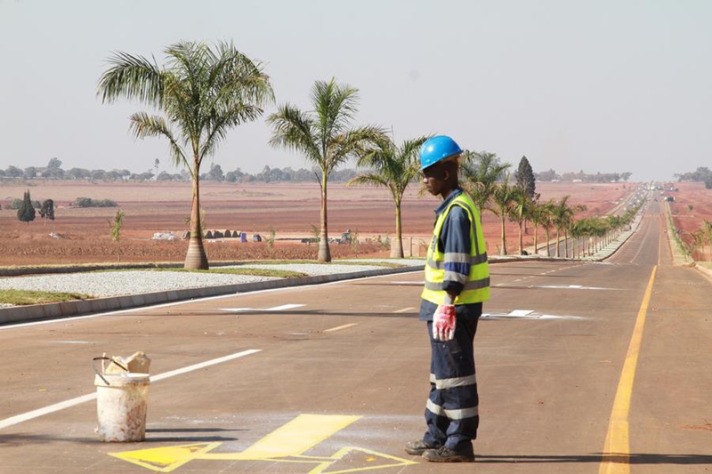 Mfanyakazi akichapa alama za kuonesha mwelekeo wa njia kwenye barabara mpya iliyojengwa nje kidogo ya Harare, mji mkuu wa Zimbabwe, Julai 20, 2024. (Picha na Tafara Mugwara/Xinhua)