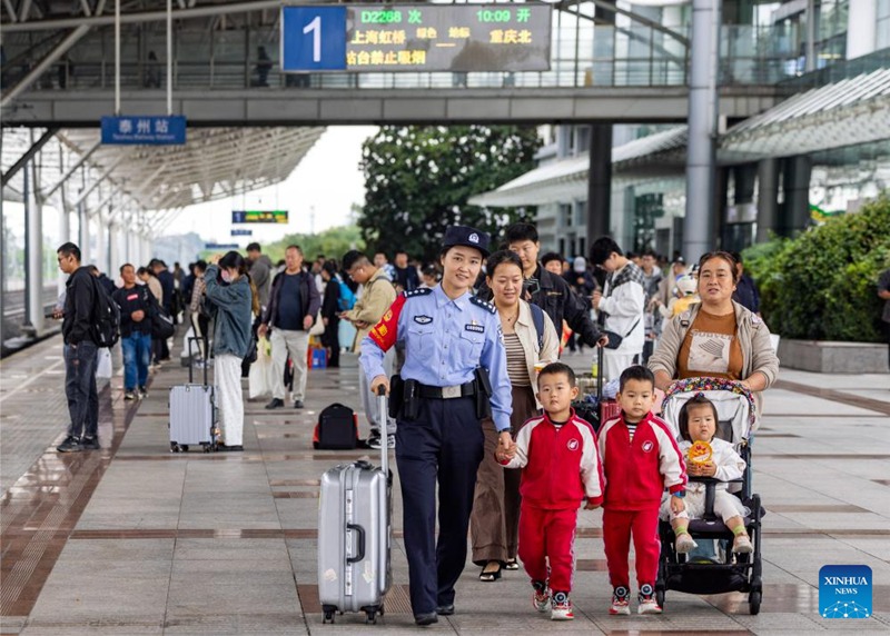 Polisi mwanamke akisaidia abiria kwenye kando ya njia ya reli katika Stesheni ya Reli ya Taizhou Mkoani Jiangsu, Mashariki mwa China, Oktoba 6, 2024. (Picha na Tang Dehong/Xinhua)